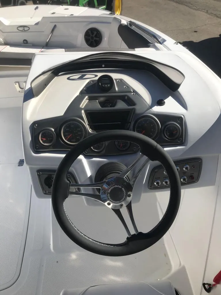 Slide: The Image of 2024 Tahoe 1950 boat dashboard with steering wheel and gauges. - 9