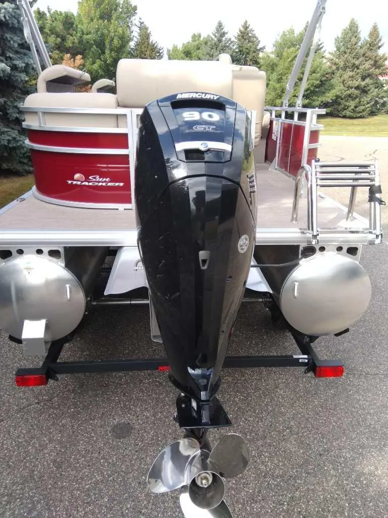 Slide: The Image of 2024 Sun Tracker Party Barge 20 DLX with Mercury outboard motor, rear view. - 2
