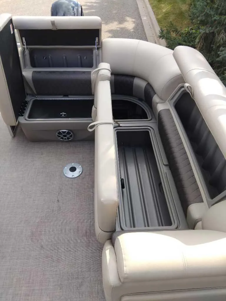 Slide: The Image of 2024 Sun Tracker Party Barge 20 DLX interior with open storage compartments. - 5