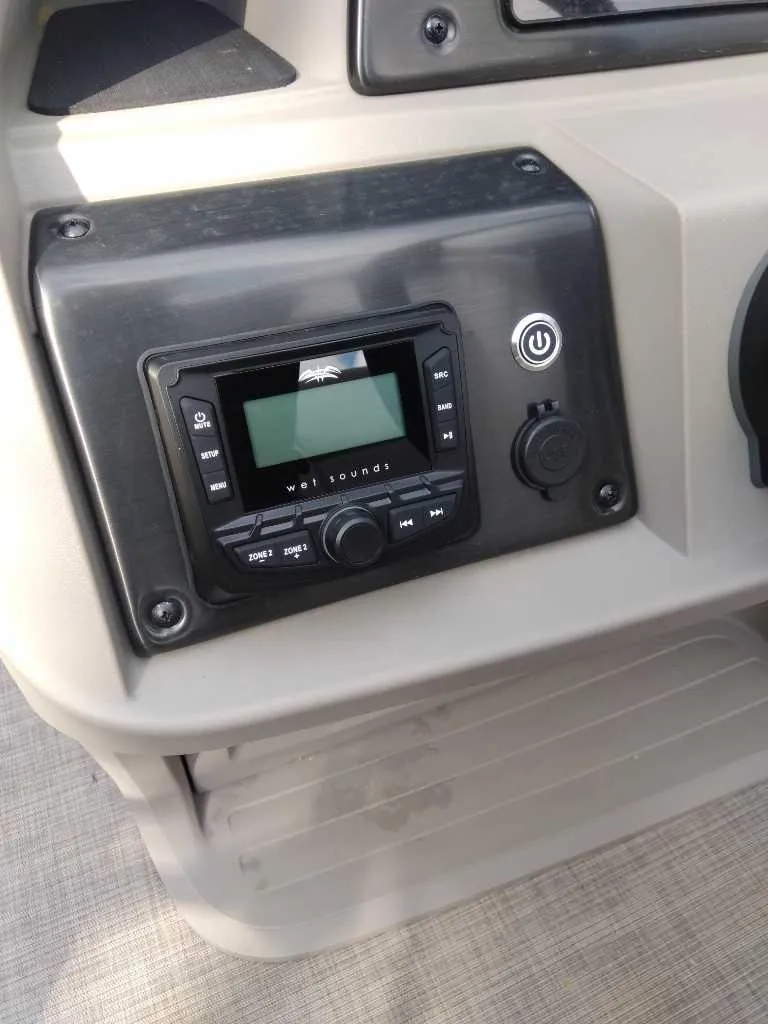 Slide: The Image of 2024 Sun Tracker Party Barge 20 DLX dashboard with audio system controls. - 7