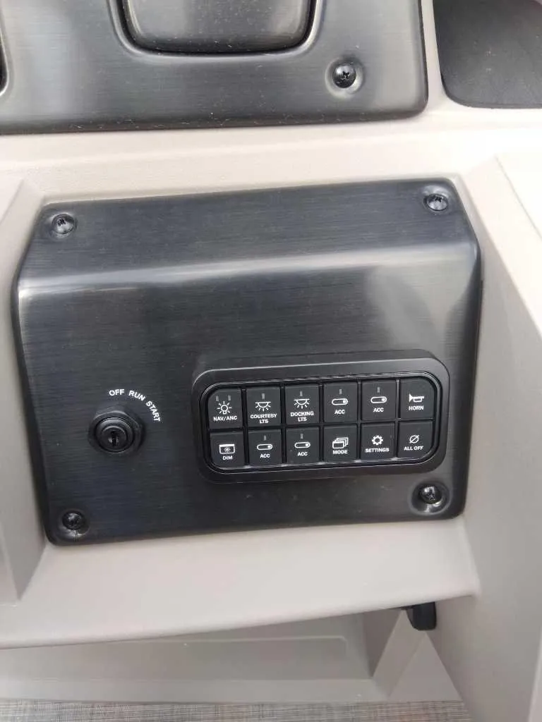 Slide: The Image of 2024 Sun Tracker Party Barge 20 DLX control panel with switches and buttons. - 8