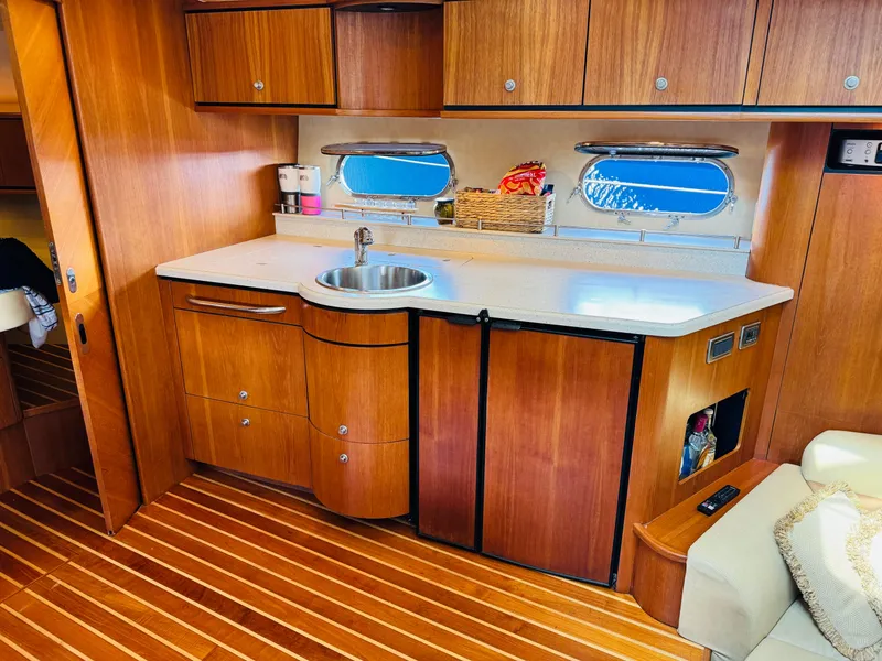 Slide: The Image of 2007 Tiara Yachts 3900 Sovran galley with wood cabinetry, sink, and mini-fridge. - 10