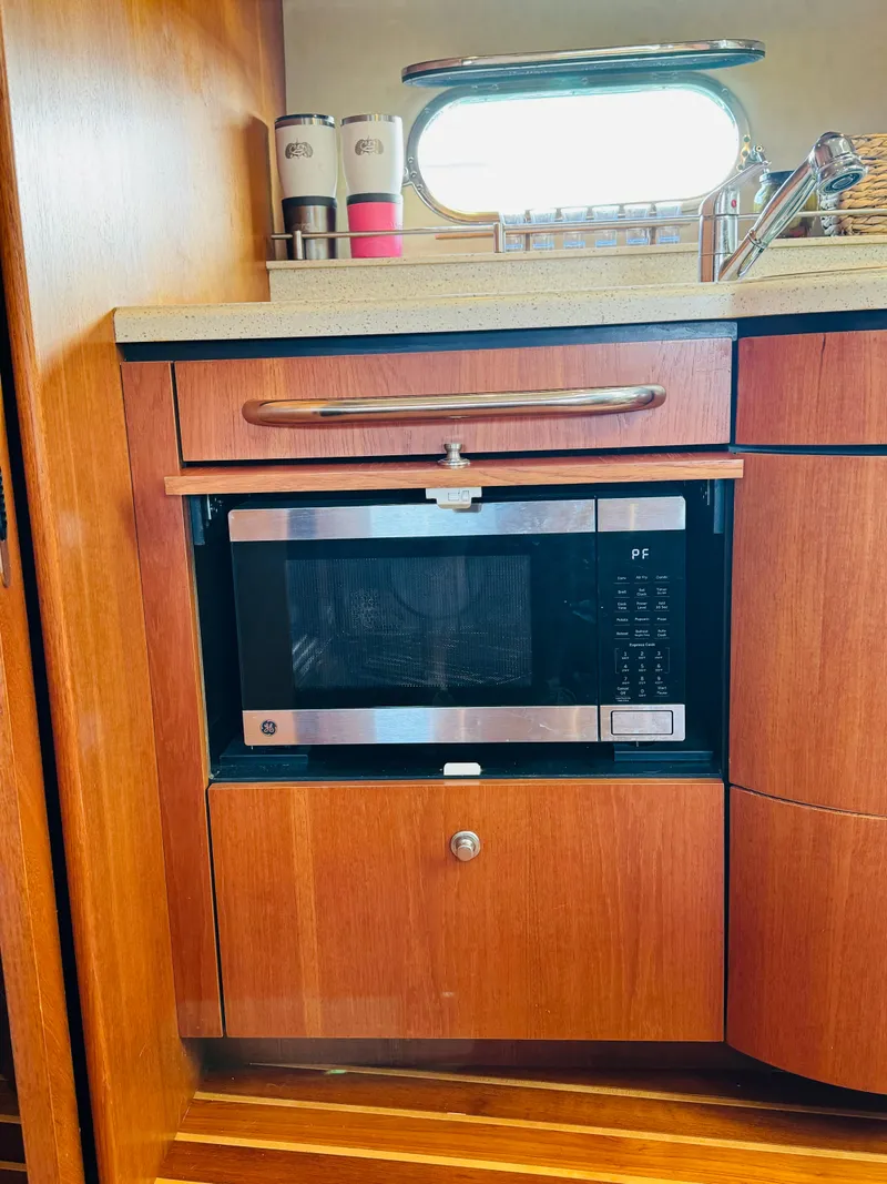 Slide: The Image of 2007 Tiara Yachts 3900 Sovran kitchen with microwave and wooden cabinetry. - 12
