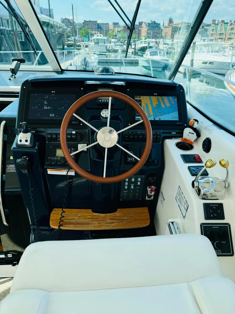 Slide: The Image of Helm of a 2007 Tiara Yachts 3900 Sovran with wooden steering wheel and modern controls. - 24