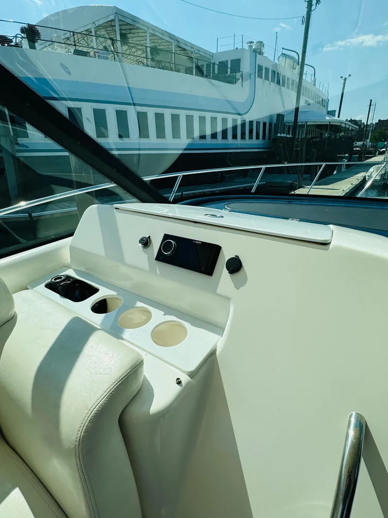 Slide: The Image of 2007 Tiara Yachts 3900 Sovran helm station with cup holders and control panel. - 30