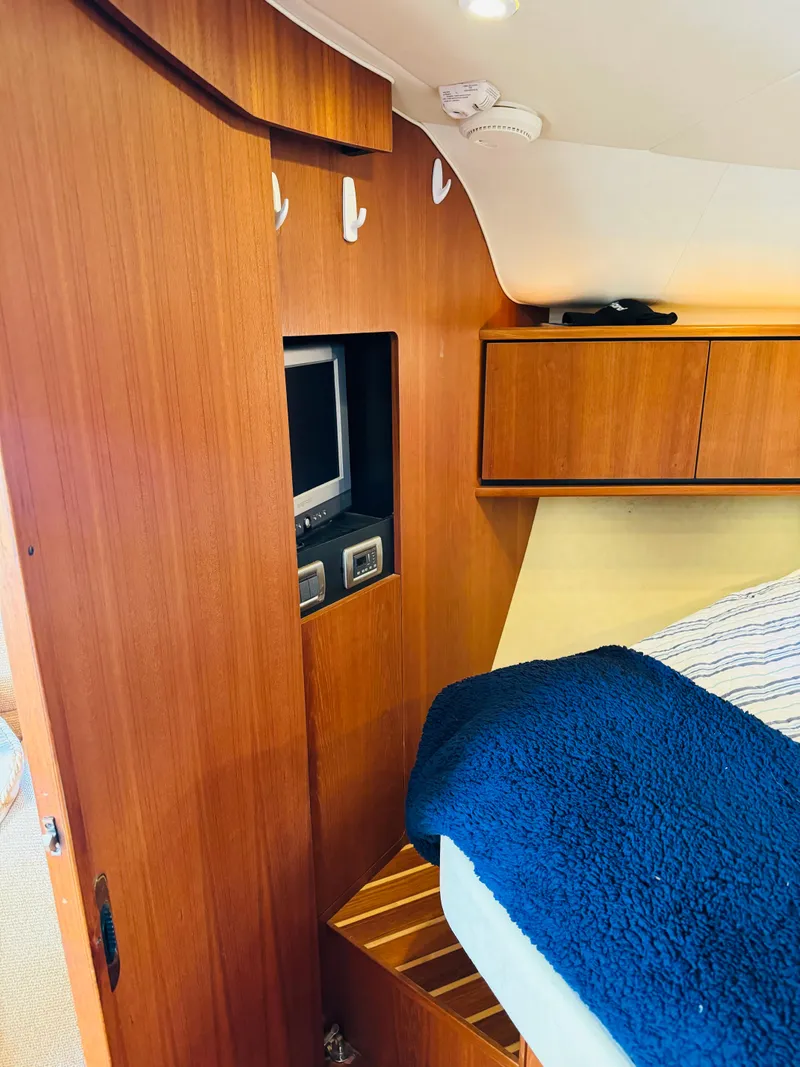 Slide: The Image of 2007 Tiara Yachts 3900 Sovran cabin interior with wooden cabinetry and built-in TV. - 5