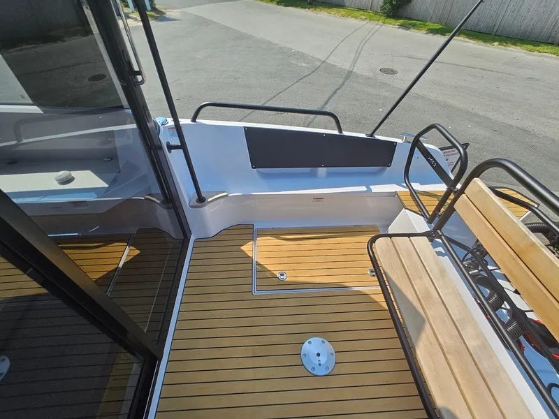 Slide: The Image of 2023 XO Boats EXPLR 10 Sport Plus deck with wooden flooring and seating area. - 11