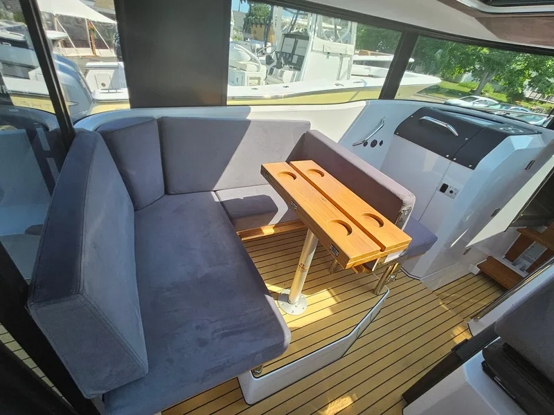 Slide: The Image of Interior of 2023 XO Boats EXPLR 10 Sport Plus with seating and wooden table. - 16