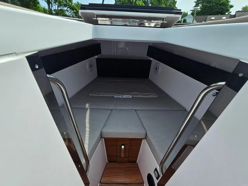 Slide: The Image of 2023 XO Boats EXPLR 10 Sport Plus cabin interior with cushioned seating and wooden flooring. - 26