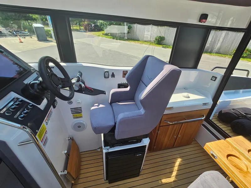 Slide: The Image of 2023 XO Boats EXPLR 10 Sport Plus cockpit with steering wheel and captain's chair. - 18