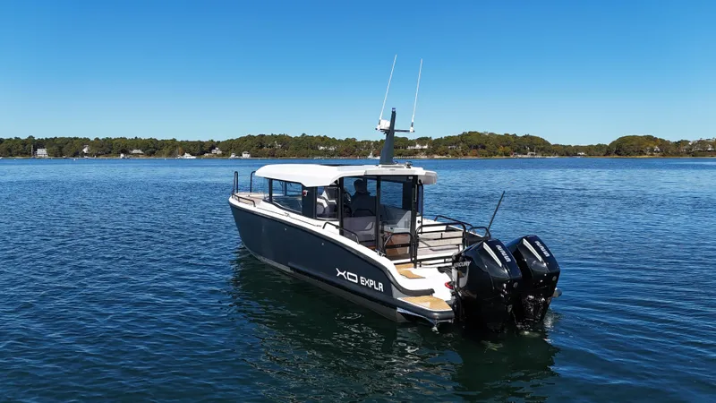 Slide: The Image of 2023 XO Boats EXPLR 10 Sport Plus on calm water, showcasing sleek design and dual engines. - 3