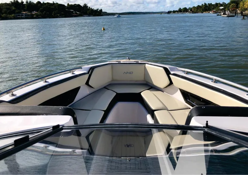 Slide: The Image of NHD 255 Open Deck 2025 boat on a serene lake with cushioned seating. - 4