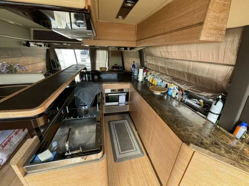 Slide: The Image of Modern kitchen interior of 2013 Azimut 64 Fly yacht with wooden cabinetry and marble countertops. - 14