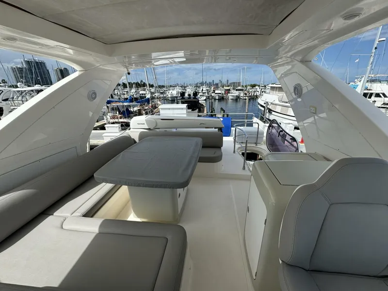 Slide: The Image of 2013 Azimut 64 Fly yacht interior with seating and table, docked at marina. - 27
