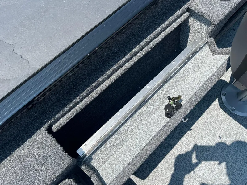 Slide: The Image of 2025 Lund 1675 Adventure Sport boat storage compartment with carpeted interior. - 14