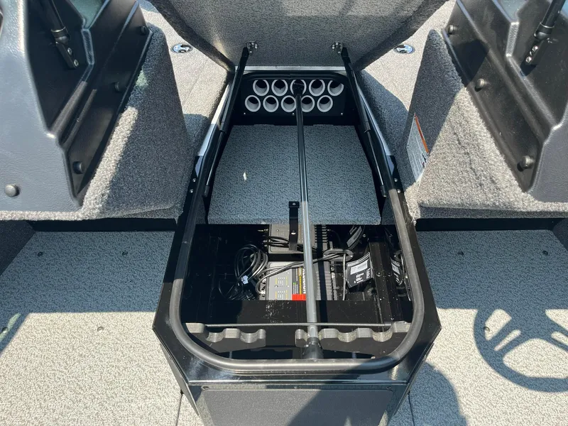 Slide: The Image of 2025 Lund 1675 Adventure Sport boat storage compartment with battery and rod holders. - 15