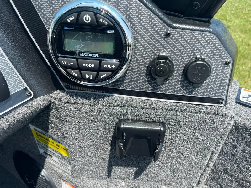 Slide: The Image of 2025 Lund 1675 Adventure Sport boat dashboard with Kicker audio system and power outlets. - 17
