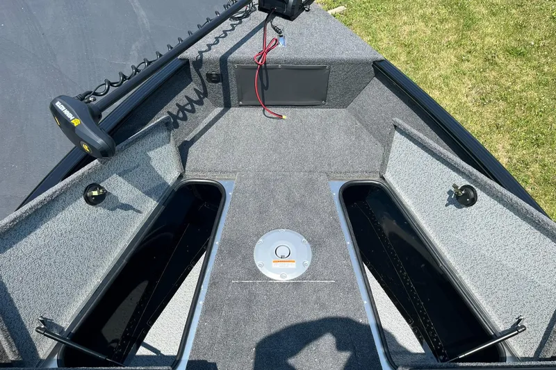 Slide: The Image of 2025 Lund 1675 Adventure Sport boat interior with storage compartments and trolling motor. - 19