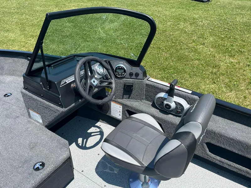 Slide: The Image of 2025 Lund 1675 Adventure Sport boat cockpit with steering wheel and captain's chair. - 8