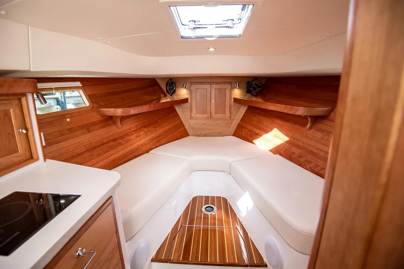 Slide: The Image of 2025 MJM 35 boat interior with wooden finish and white seating. - 18