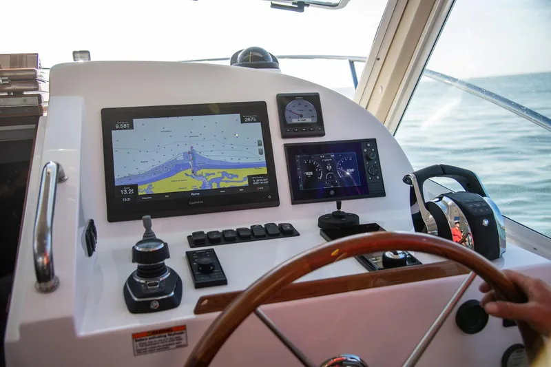 Slide: The Image of Control panel of 2025 MJM 35 boat with navigation screens and steering wheel. - 23