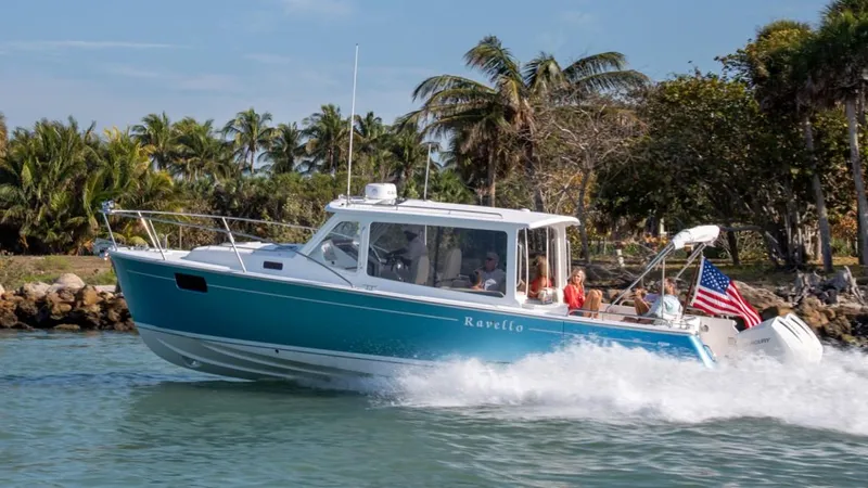 Slide: The Image of 2025 MJM 35 boat cruising on water with passengers, palm trees in background. - 25