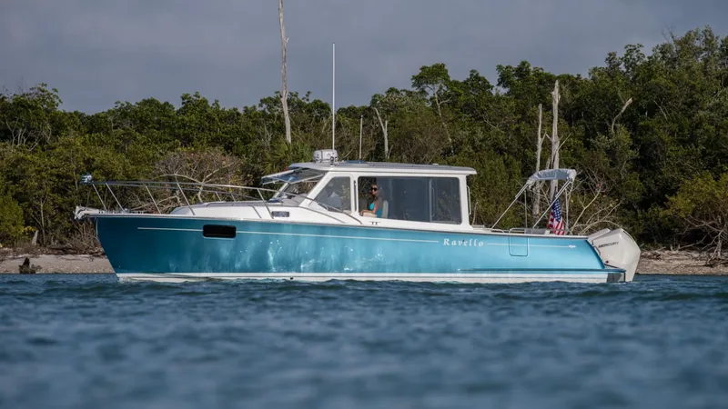 Slide: The Image of 2025 MJM 35 boat cruising near a forested shoreline. - 3