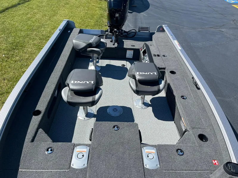 Slide: The Image of 2025 Lund 1875 Pro Guide fishing boat interior with two seats and motor. - 11