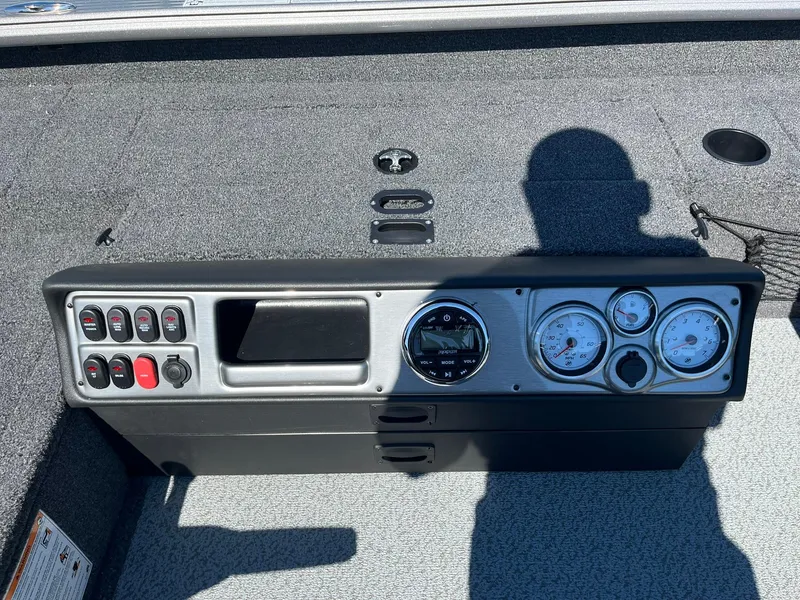 Slide: The Image of 2025 Lund 1875 Pro Guide boat dashboard with gauges and control switches. - 13