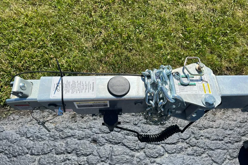 Slide: The Image of Trailer hitch of a 2025 Lund 1875 Pro Guide boat on a paved surface. - 28