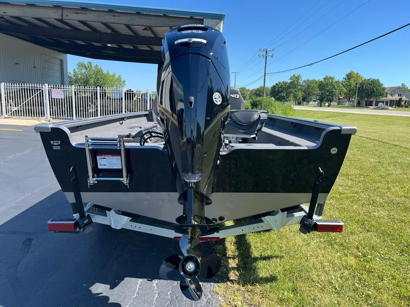 Slide: The Image of 2025 Lund 1875 Pro Guide boat with outboard motor, parked outdoors. - 4