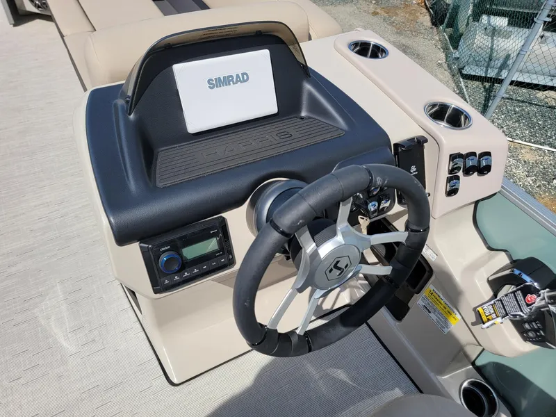 Slide: The Image of 2025 Harris Cruiser 230 boat dashboard with steering wheel and Simrad display. - 11