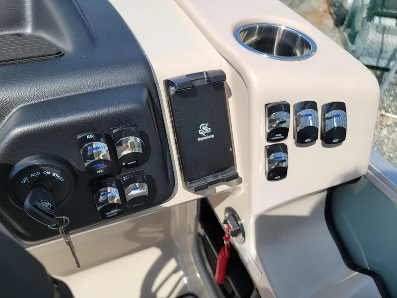 Slide: The Image of Dashboard controls of 2025 Harris Cruiser 230 boat with key ignition and cup holder. - 14