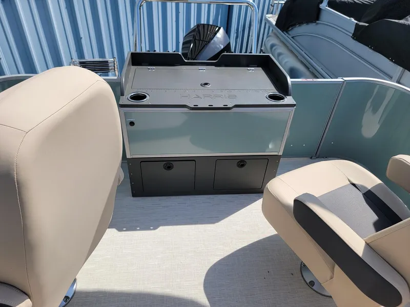 Slide: The Image of 2025 Harris Cruiser 230 boat interior with beige seats and storage console. - 17
