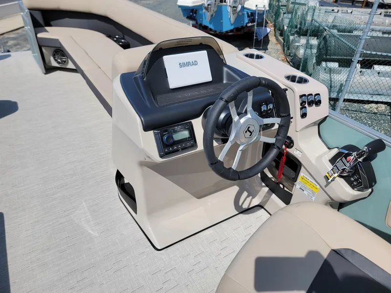 Slide: The Image of 2025 Harris Cruiser 230 boat helm with steering wheel and control panel. - 26