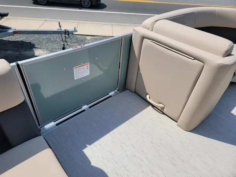 Slide: The Image of 2025 Harris Cruiser 230 boat interior with beige seating and safety gate. - 27