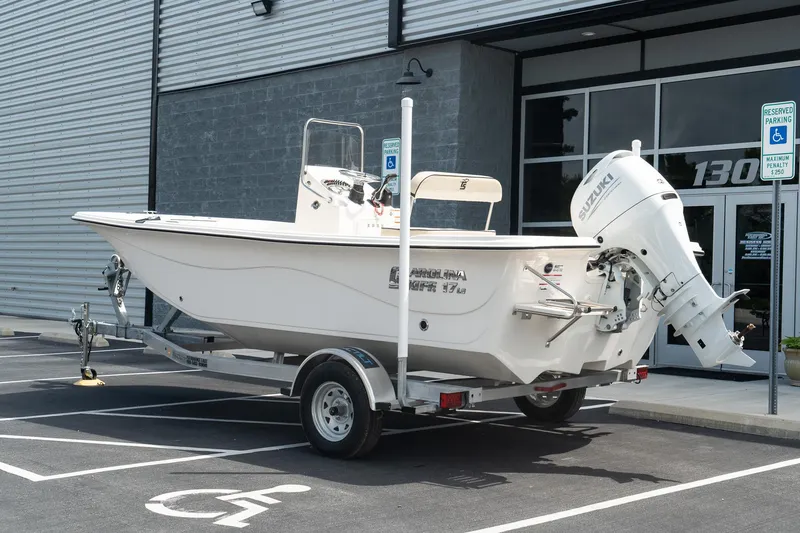 The Image of 2024 Carolina Skiff 17 LS boat on a trailer in a parking lot. - 1