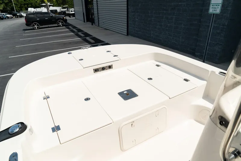 Slide: The Image of 2024 Carolina Skiff 17 LS boat deck with storage compartments in a parking lot. - 12