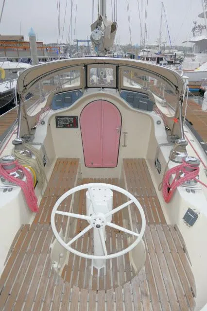 Slide: The Image of 1970 Southern Ocean GALLANT 53 sailboat cockpit with wooden deck and pink cabin door. - 38