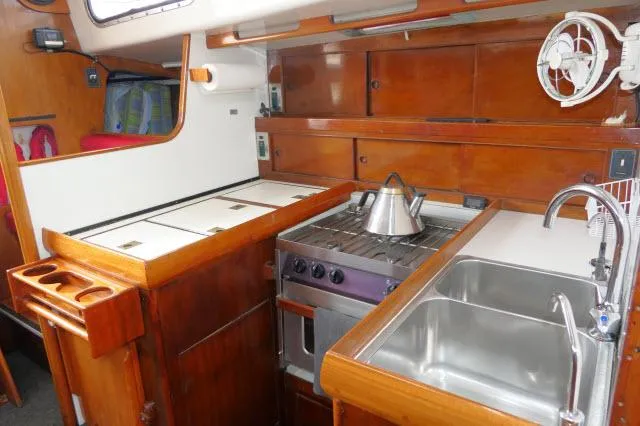 Slide: The Image of 1970 Southern Ocean GALLANT 53 yacht kitchen with stove, sink, and wooden cabinetry. - 7