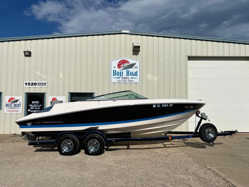Slide: The Image of 2006 Regal 2200 Bowrider boat on a trailer outside Boji Boat Brokers. - 0