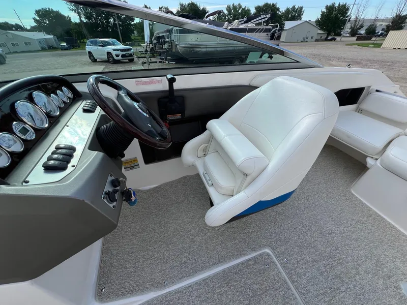 Slide: The Image of 2006 Regal 2200 Bowrider boat interior with steering wheel and white seating. - 16