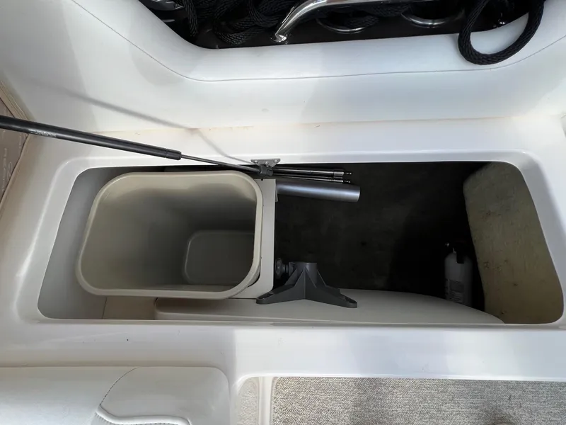 Slide: The Image of Storage compartment of a 2006 Regal 2200 Bowrider boat with a trash bin and accessories. - 21