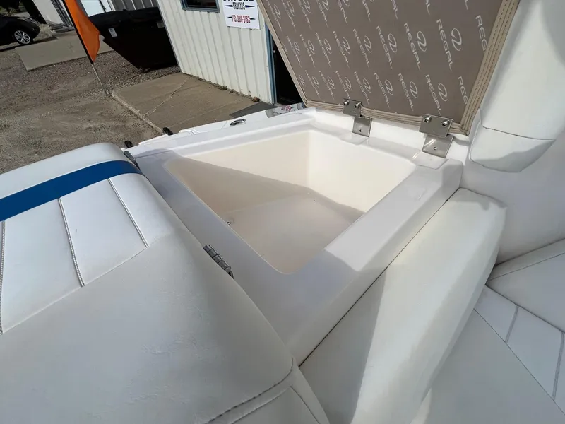 Slide: The Image of 2006 Regal 2200 Bowrider boat with open storage compartment and white seating. - 22