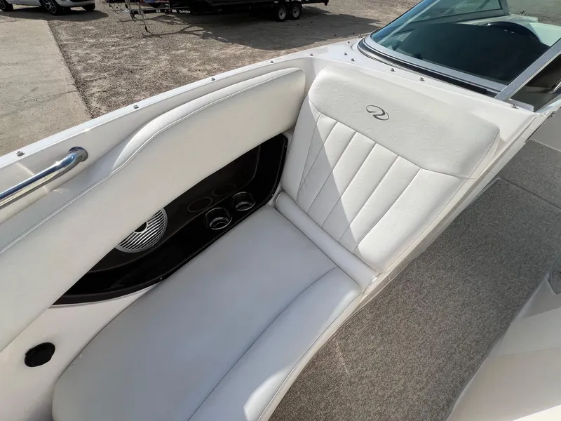 Slide: The Image of 2006 Regal 2200 Bowrider boat interior with white cushioned seating and cup holders. - 9