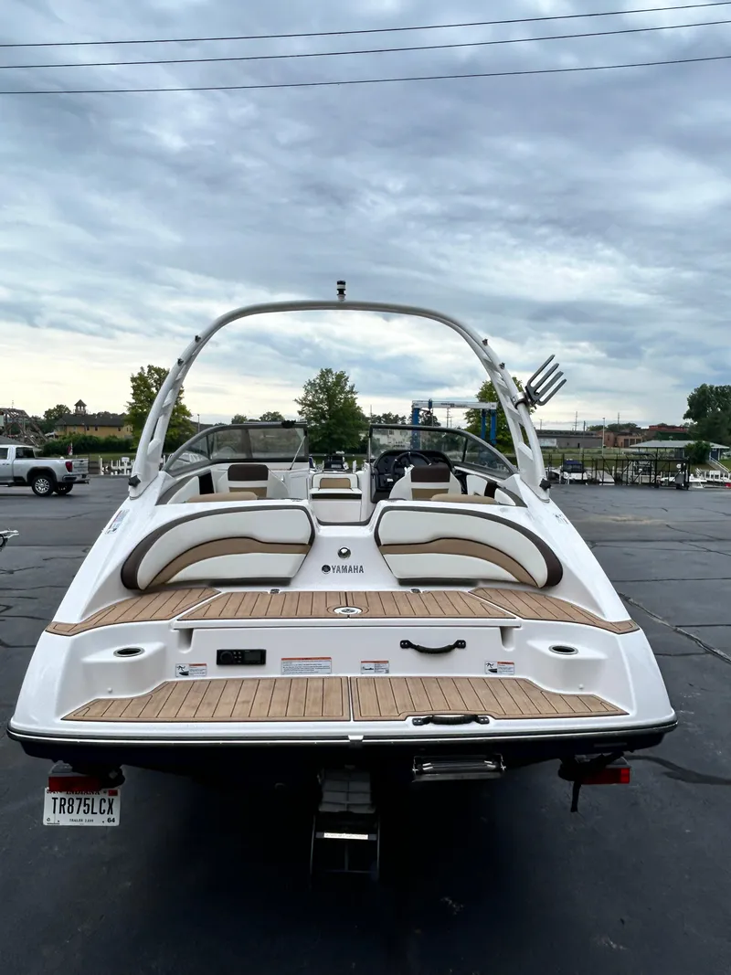 Slide: The Image of 2022 Yamaha Boats 195 S, rear view, docked in a parking lot. - 2
