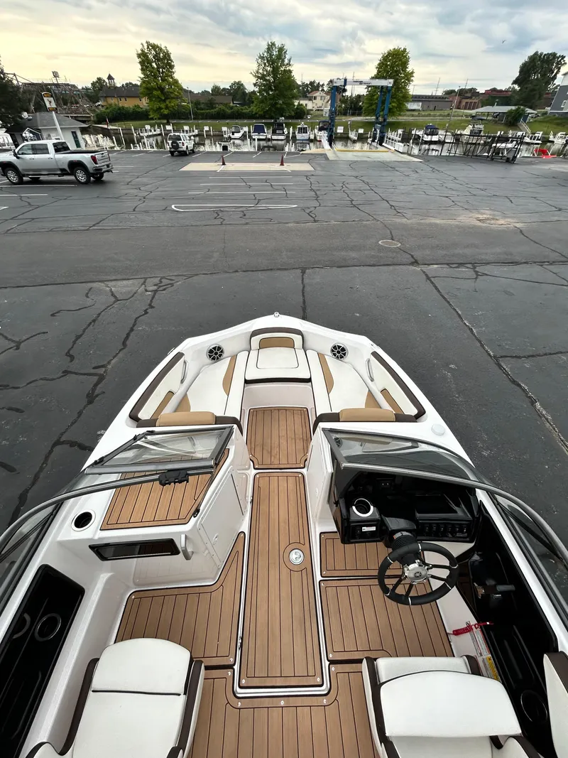 Slide: The Image of 2022 Yamaha Boats 195 S with teak flooring, docked at a marina. - 6