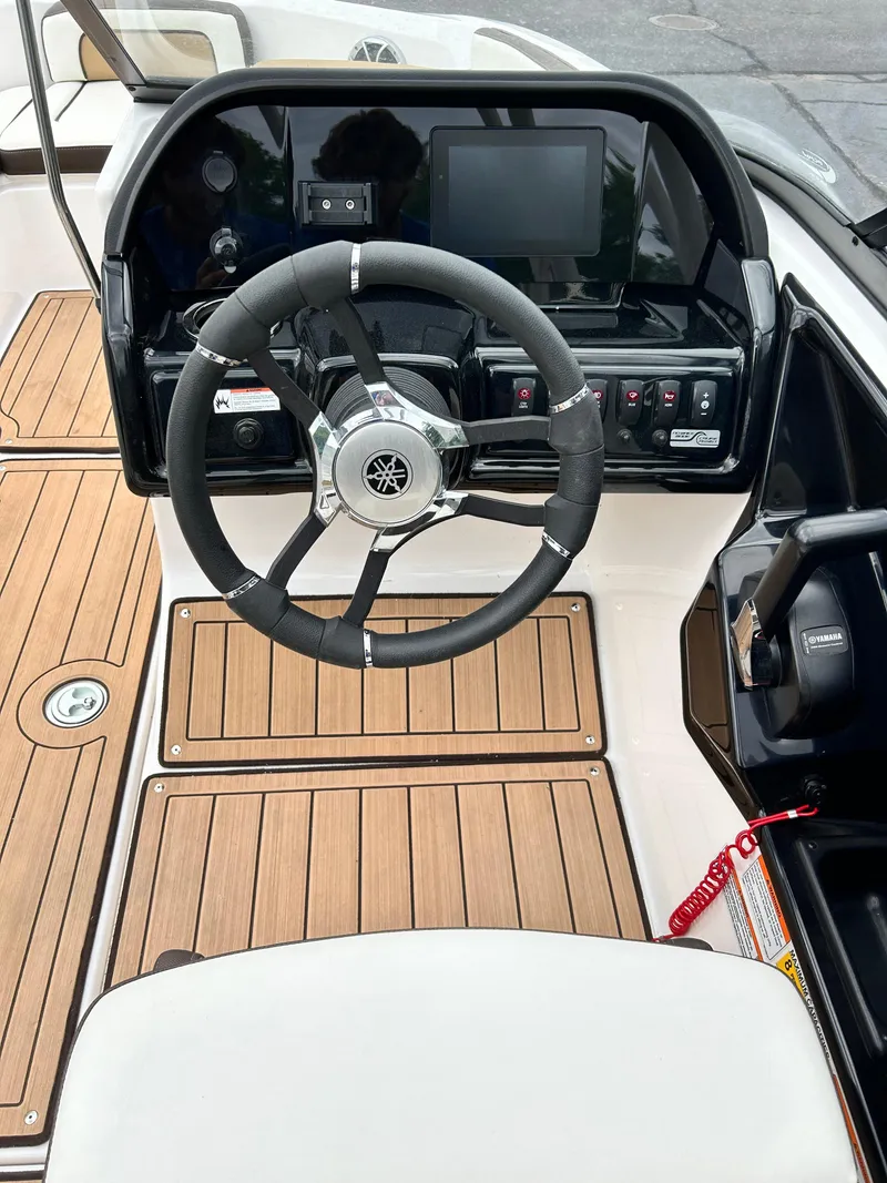 Slide: The Image of 2022 Yamaha Boats 195 S steering console with modern controls and wooden flooring. - 7