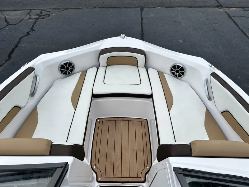 Slide: The Image of 2022 Yamaha Boats 195 S bow seating area with white and tan upholstery. - 8