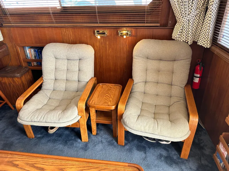 Slide: The Image of Two cushioned chairs and a small table in a 1985 Hatteras 36 Convertible yacht interior. - 10